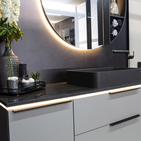 Modische Badezimmerkombination in Taupe mit schwarzen Griffe, Aufsatzwaschbecken in Graphite, Marmorstein-Platten und eleganter schwarzer Armatur.