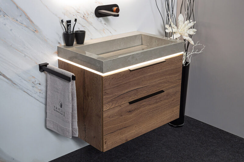 Badezimmerkombination: Tabakeiche mit schwarzen Griffen, Marmorzement Waschbecken, elegante schwarze Armatur.