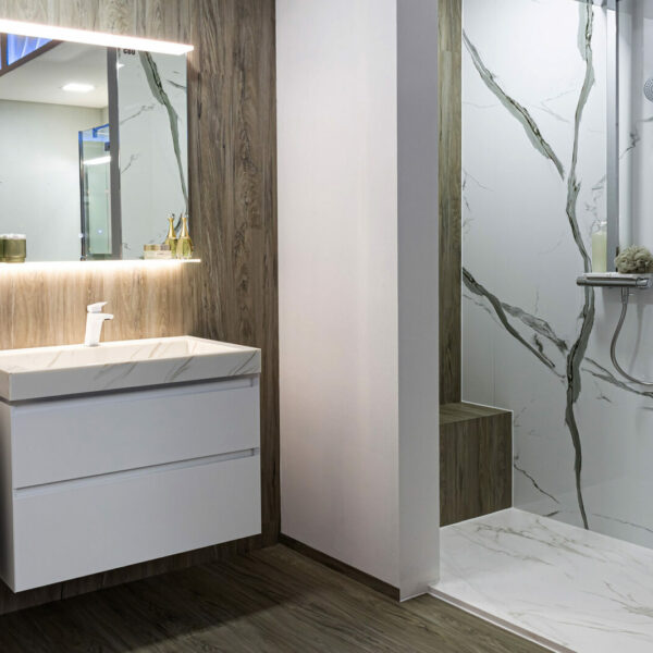 Exklusive Gäste-WC Badmöbel: Weißer 60-80 cm Waschtisch mit stilvollem Carrara Waschbecken, heller Spiegel mit einzigartiger beleuchteter Ablage.